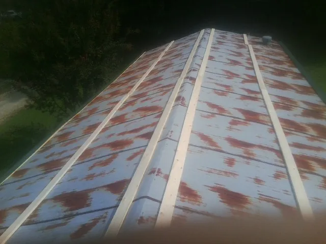Rusted metal roof panels with new wood purlins before replacement — Storm Damage Roof Repair in Kirtland Afb by Roofing Brothers