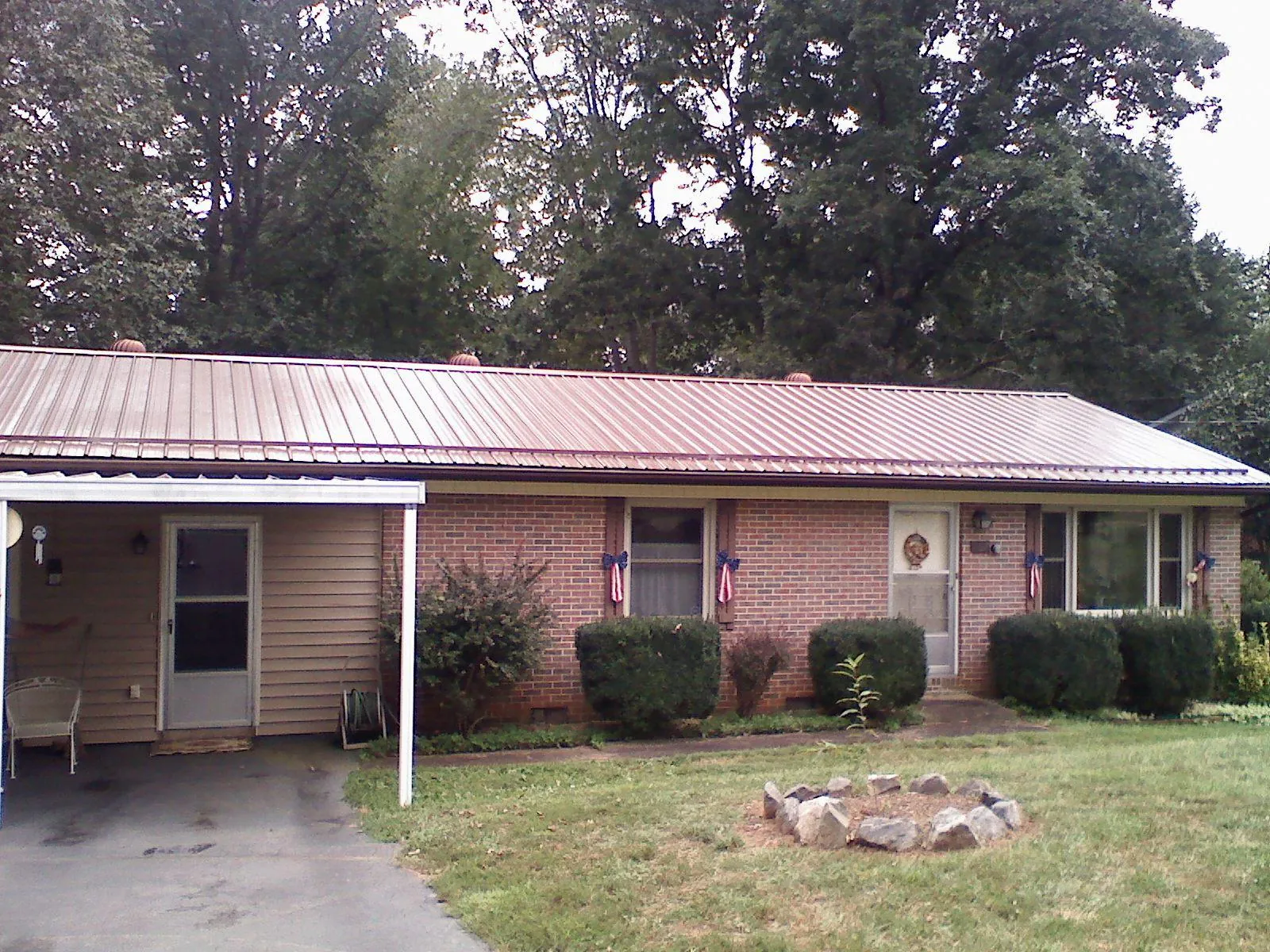 Bronze metal roof and carport on a brick ranch home — Roof Repair work by our crew in Kirtland Afb
